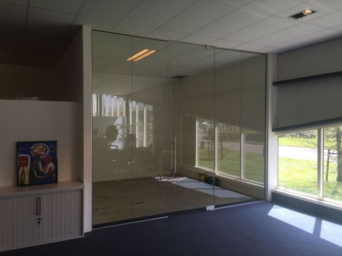 Verdiepingshoge pendeldeur in een glaswand