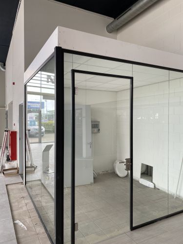 Vrijstaand glazen kantoor met zwarte profielen