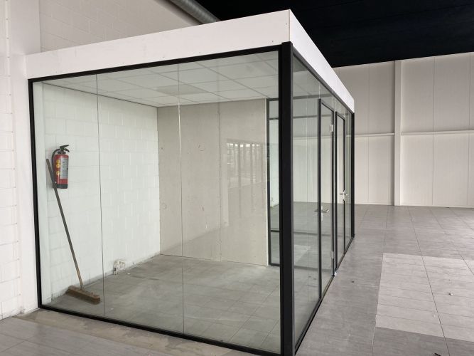 Vrijstaand glazen kantoor met zwarte profielen