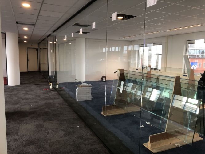 Glaswand met zwarte profielen en pendeldeuren