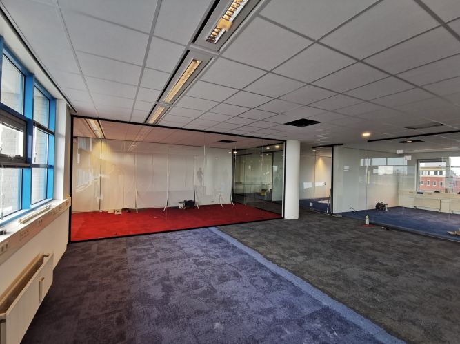 Glaswand met zwarte profielen en pendeldeuren