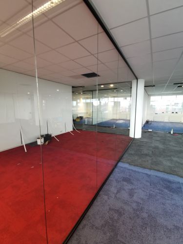 Glaswand met zwarte profielen en pendeldeuren