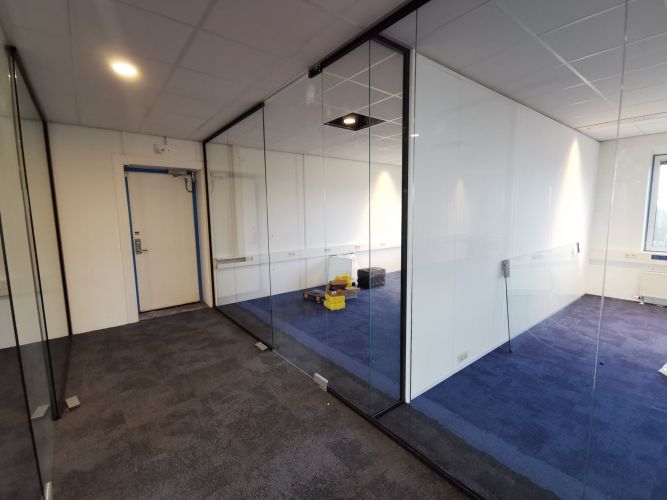 Glaswand met zwarte profielen en pendeldeuren