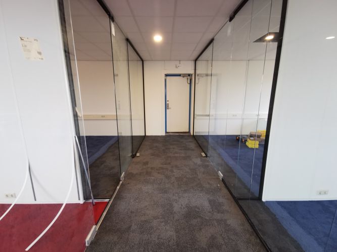 Glaswand met zwarte profielen en pendeldeuren