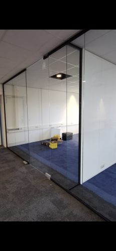 Glaswand met zwarte profielen en pendeldeuren